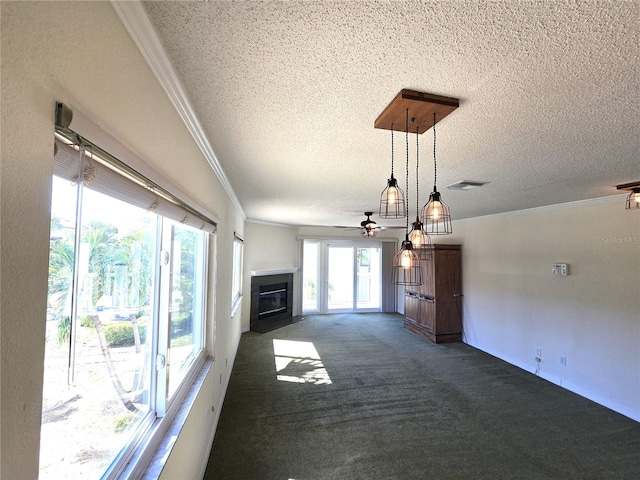 unfurnished living room with french doors, a textured ceiling, dark colored carpet, and ornamental molding