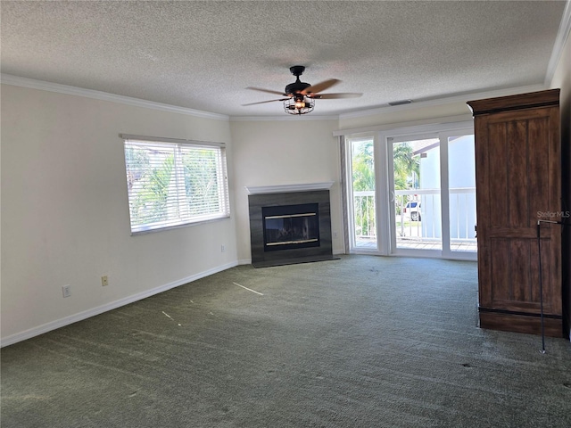 unfurnished living room with ornamental molding, dark colored carpet, ceiling fan, and plenty of natural light