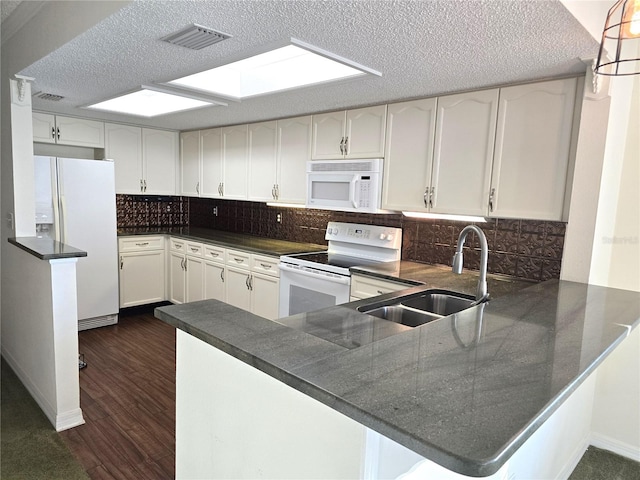 kitchen featuring sink, kitchen peninsula, white appliances, backsplash, and dark wood-type flooring