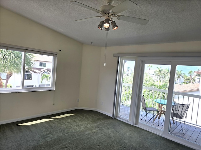 unfurnished room with a textured ceiling, lofted ceiling, dark carpet, and ceiling fan