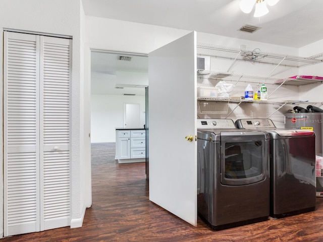 laundry area with ceiling fan, gas water heater, dark wood-type flooring, and washing machine and clothes dryer