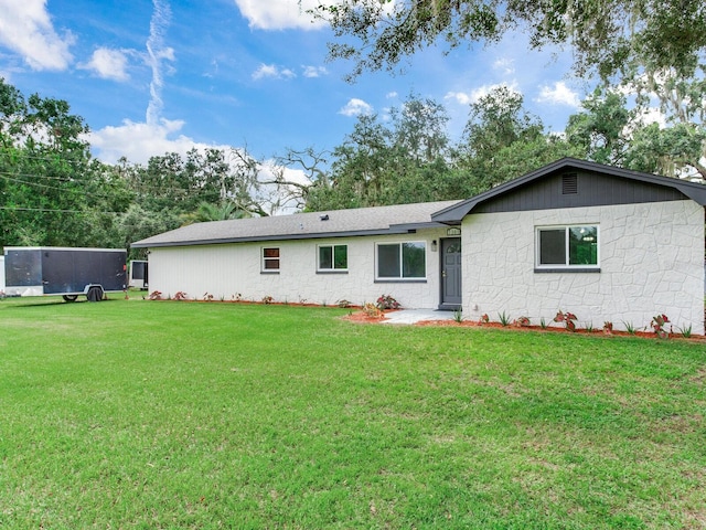 rear view of property featuring a yard