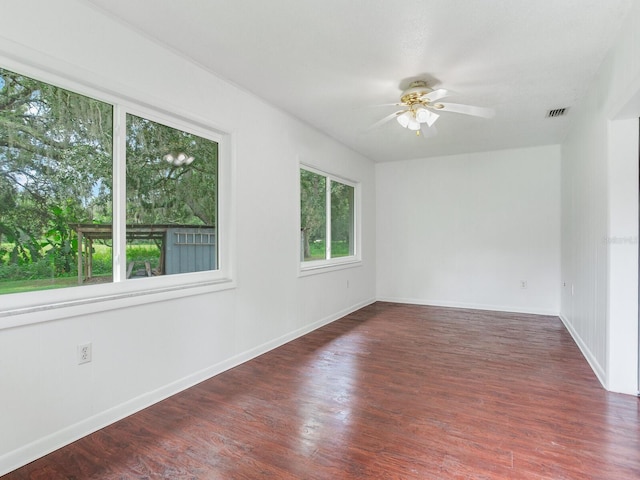 empty room with ceiling fan and dark hardwood / wood-style floors