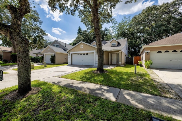 view of property with a garage and a front lawn