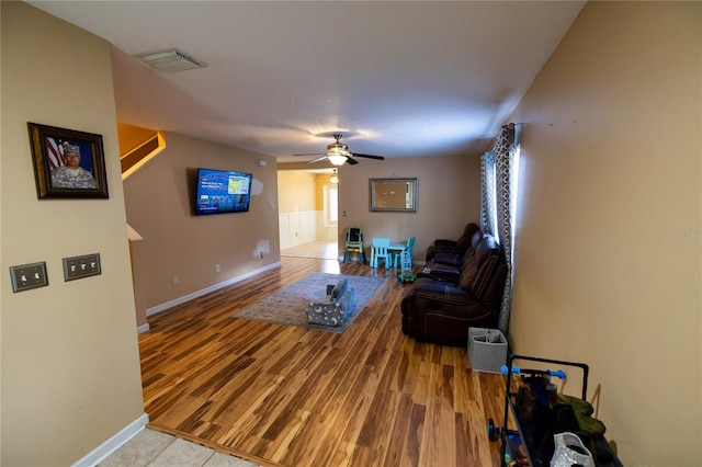 living room featuring ceiling fan, light hardwood / wood-style floors, and a healthy amount of sunlight