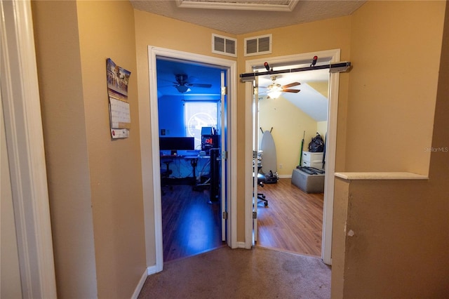 hall featuring a textured ceiling and hardwood / wood-style floors