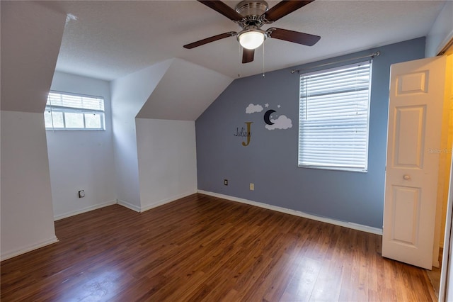 bonus room with a textured ceiling, lofted ceiling, ceiling fan, and dark hardwood / wood-style flooring