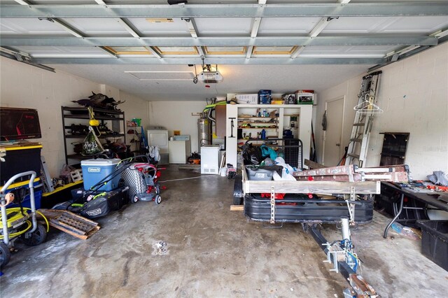 garage featuring a garage door opener, separate washer and dryer, and water heater