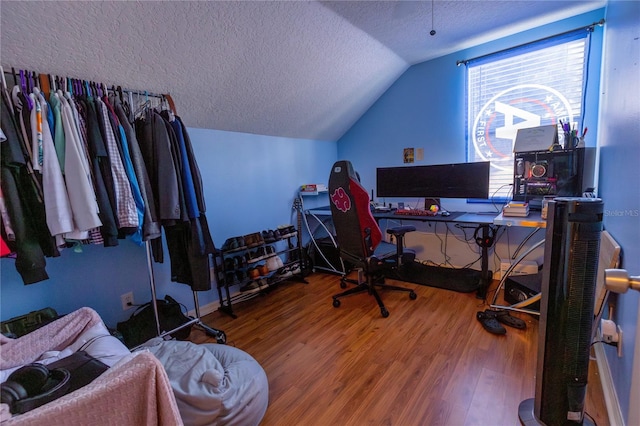 office area featuring a textured ceiling, wood-type flooring, and vaulted ceiling