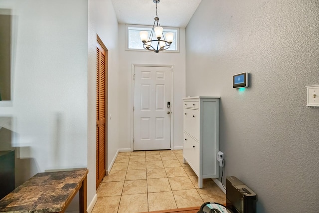 foyer entrance with an inviting chandelier, lofted ceiling, and light tile patterned floors