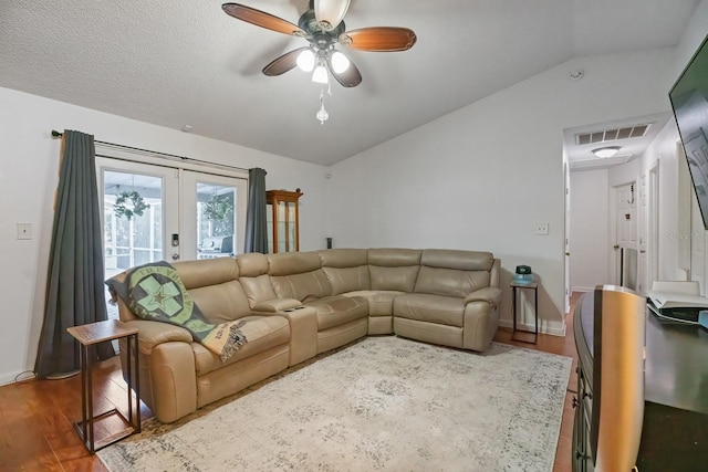 living room featuring ceiling fan, lofted ceiling, french doors, and wood-type flooring