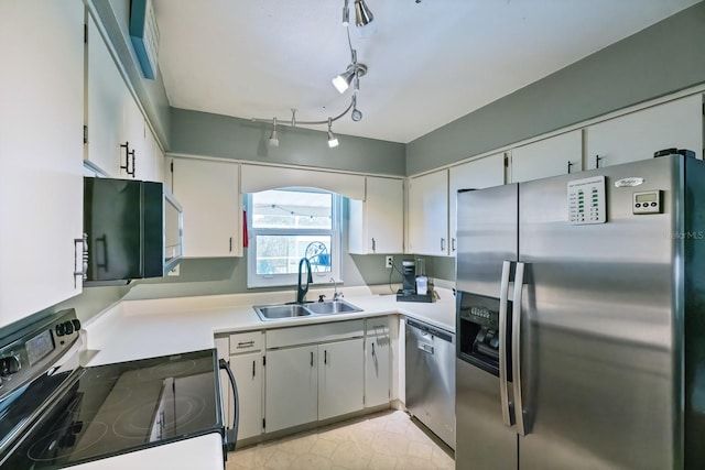 kitchen featuring rail lighting, sink, stainless steel appliances, and white cabinets