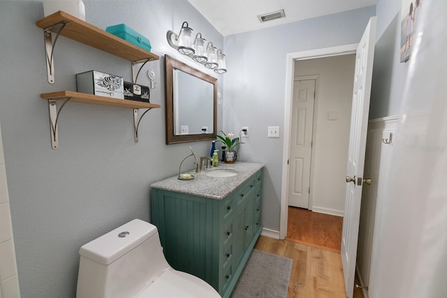 bathroom featuring wood-type flooring, vanity, and toilet