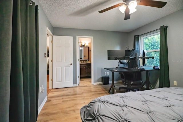 bedroom with a textured ceiling, light hardwood / wood-style floors, ceiling fan, and ensuite bathroom