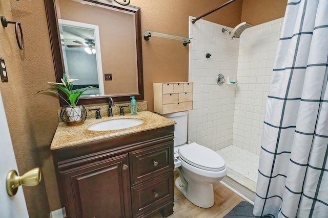 bathroom with ceiling fan, vanity, hardwood / wood-style flooring, toilet, and a shower with shower curtain