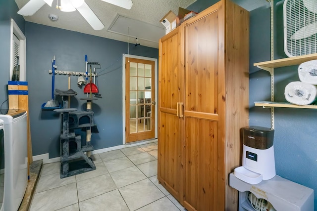 miscellaneous room featuring ceiling fan, a textured ceiling, washing machine and dryer, and tile patterned floors