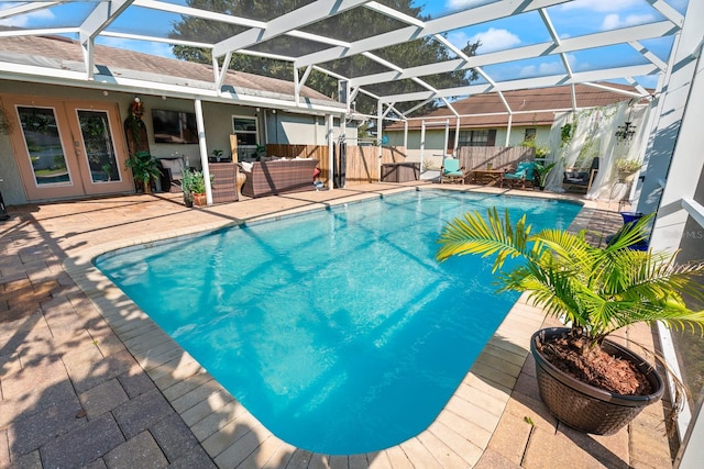 view of swimming pool featuring glass enclosure, a patio, and an outdoor hangout area