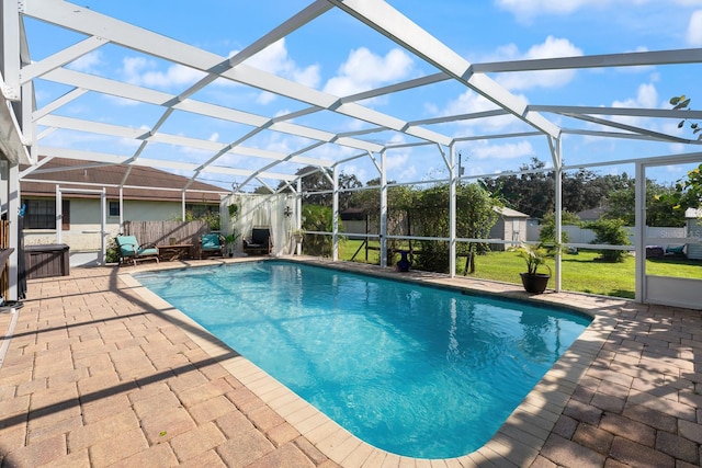 view of swimming pool with a patio, a storage shed, and a lanai