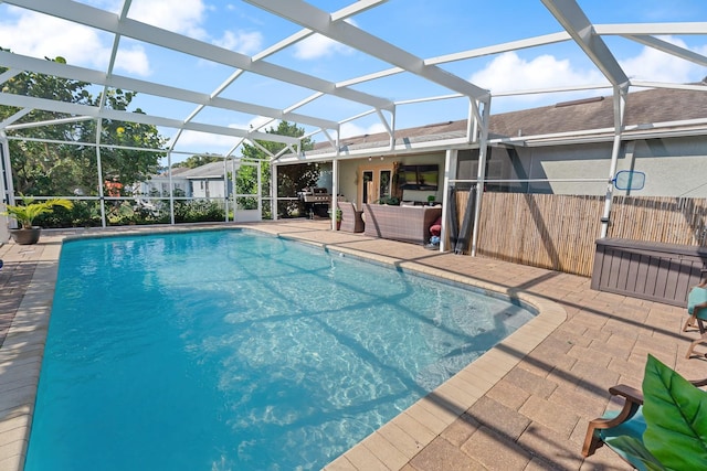 view of pool with area for grilling, a lanai, and a patio area