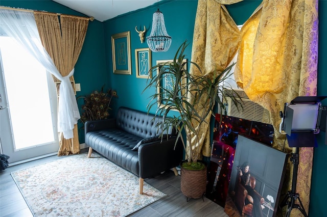 living area featuring wood-type flooring, lofted ceiling, and a notable chandelier