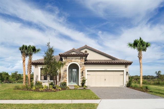 mediterranean / spanish-style home featuring a front yard and a garage