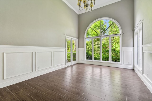 spare room with crown molding, a wealth of natural light, and a chandelier