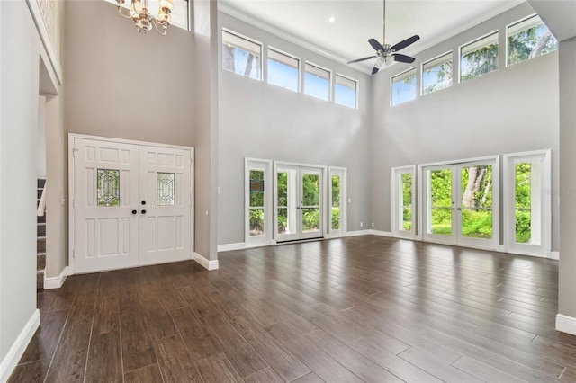 unfurnished living room featuring a towering ceiling and a wealth of natural light