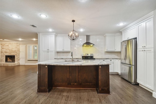 kitchen with white cabinetry, wall chimney range hood, dark hardwood / wood-style flooring, and stainless steel appliances