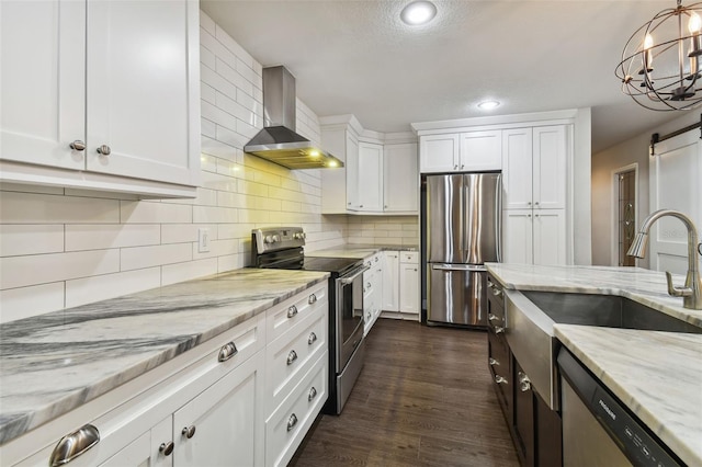 kitchen featuring appliances with stainless steel finishes, white cabinetry, dark hardwood / wood-style floors, light stone counters, and wall chimney exhaust hood