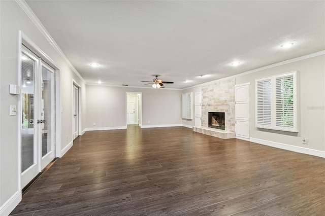 unfurnished living room featuring crown molding, dark wood-type flooring, ceiling fan, and a fireplace