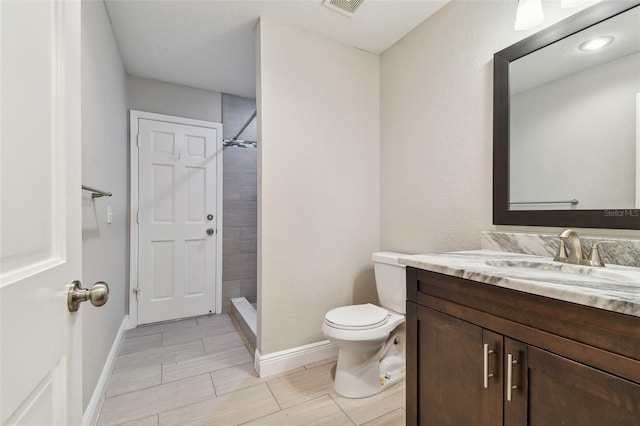 bathroom with toilet, vanity, and walk in shower