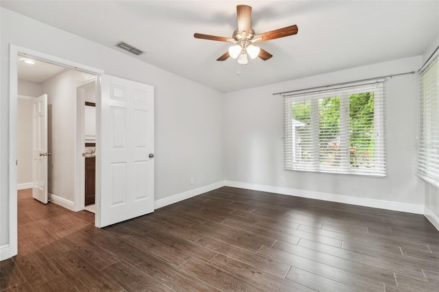 empty room with ceiling fan and dark hardwood / wood-style floors