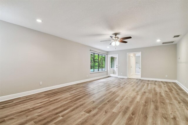 empty room with ceiling fan and light hardwood / wood-style flooring