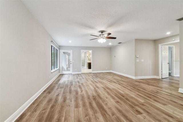 unfurnished living room with ceiling fan, light hardwood / wood-style floors, and a textured ceiling