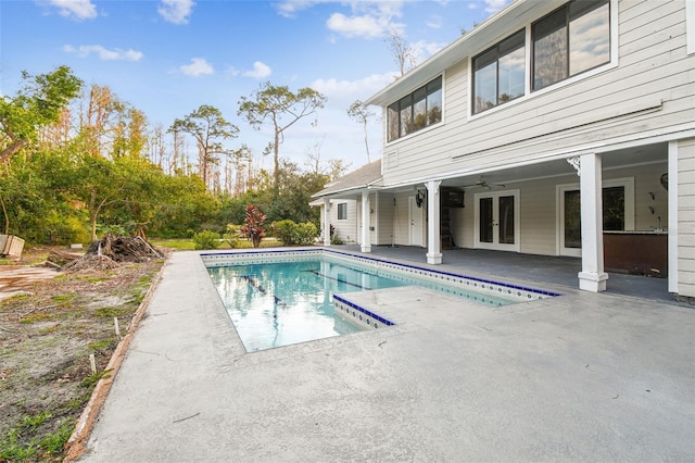 view of swimming pool with french doors, ceiling fan, and a patio area