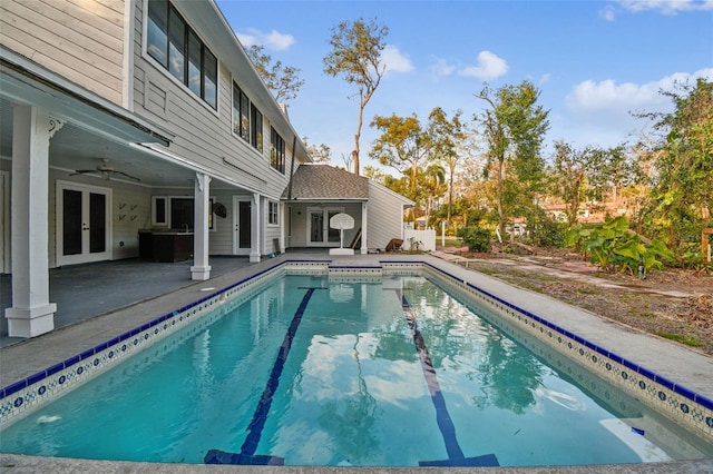 view of swimming pool with a patio, ceiling fan, and french doors