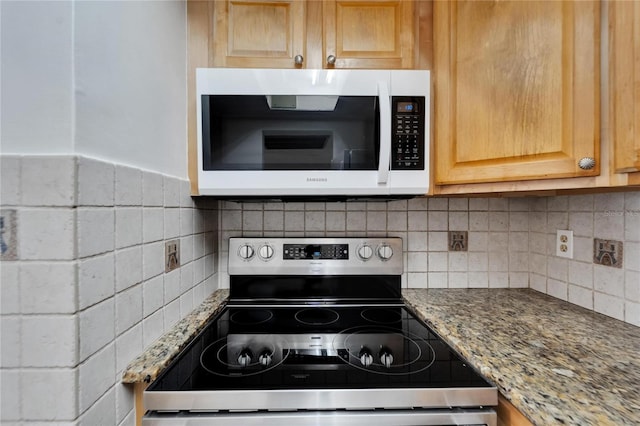 kitchen with stainless steel range with electric cooktop, light stone counters, and backsplash