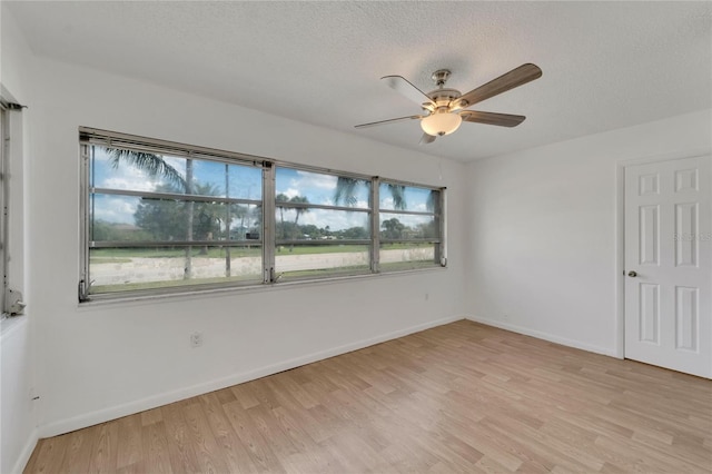 spare room with ceiling fan, light hardwood / wood-style floors, a healthy amount of sunlight, and a textured ceiling