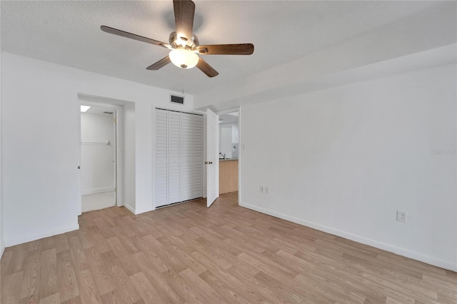 unfurnished bedroom featuring light hardwood / wood-style flooring, ceiling fan, and a textured ceiling