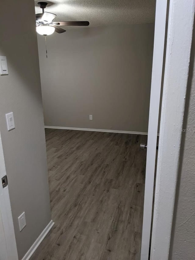 spare room with ceiling fan, dark hardwood / wood-style floors, and a textured ceiling