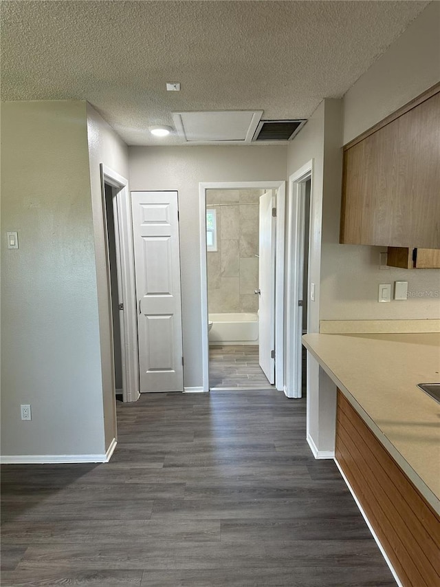 kitchen with a textured ceiling and dark hardwood / wood-style flooring