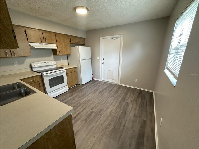 kitchen featuring sink, a textured ceiling, dark hardwood / wood-style flooring, and white appliances