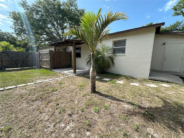 back of property featuring a patio and a yard