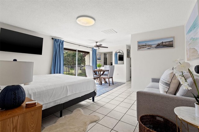 bedroom featuring ceiling fan, light tile patterned floors, a textured ceiling, and access to outside