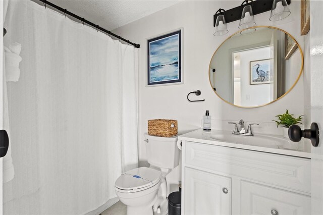 bathroom featuring vanity, a textured ceiling, and toilet