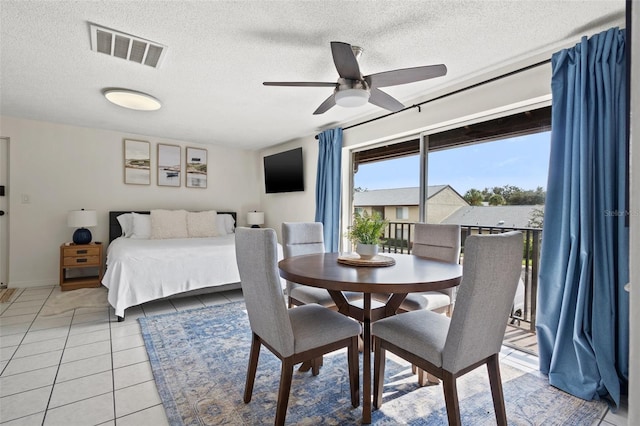 tiled bedroom with a textured ceiling and ceiling fan