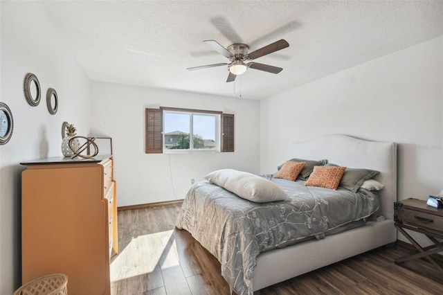 bedroom featuring a textured ceiling, dark hardwood / wood-style floors, and ceiling fan