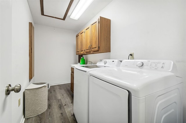 clothes washing area with cabinets, wood-type flooring, and independent washer and dryer