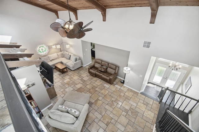 living room with wooden ceiling, ceiling fan with notable chandelier, beamed ceiling, and high vaulted ceiling