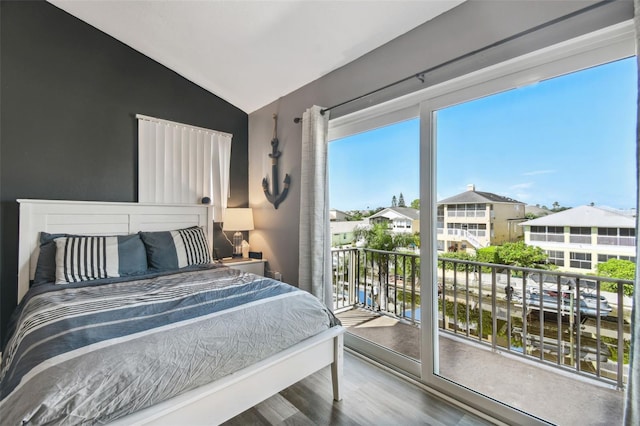 bedroom featuring lofted ceiling, access to outside, and hardwood / wood-style floors